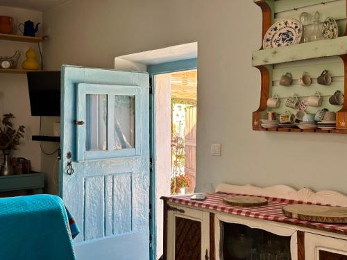 a room with an open door and a table with dishes at Atelier 20th in Ervidel