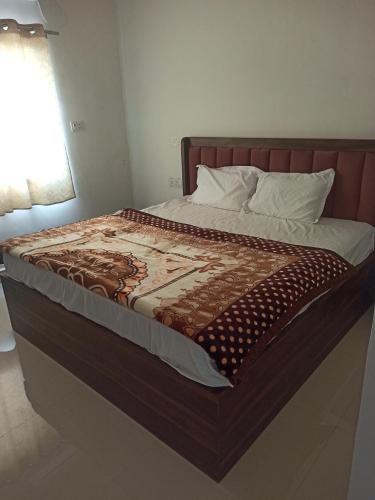 a bed in a bedroom with a brown blanket on it at Abhiram Homestay in Khajurāho