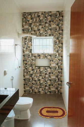 a bathroom with a toilet and a window at Chacara Las Palomas in Presidente Epitácio