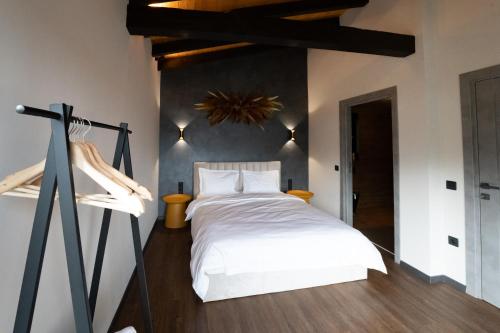 a bedroom with a white bed and a tripod at Balada dintre dealuri - Casa Soarelui si Casa Lunii in Cisnadioara