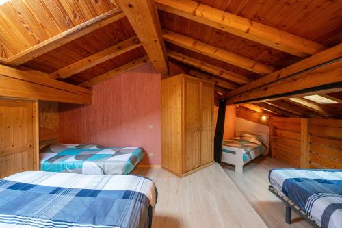 Dos camas en una habitación con techos de madera. en Mountain Lover - Joli studio au pied des pistes, en Peisey-Nancroix