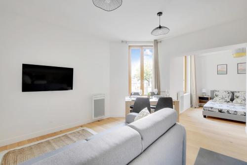 un salon avec un canapé et une télévision dans l'établissement Flexliving - Studio - Fessart, à Paris