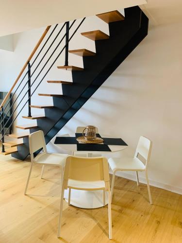 une salle à manger avec une table et des chaises et un escalier dans l'établissement Charmant duplex, à Pornic