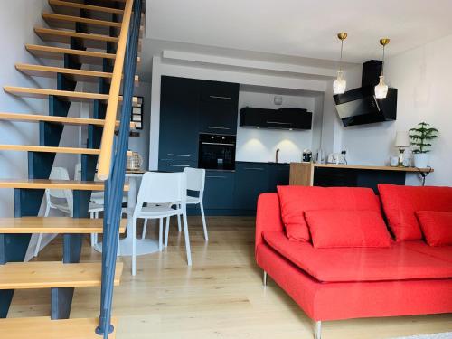 un salon avec un canapé rouge et une cuisine dans l'établissement Charmant duplex, à Pornic