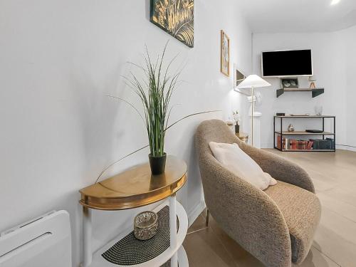 un salon avec une chaise et une table avec une plante dans l'établissement Le Refuge Méditerranéen, à Marseille