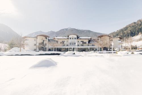 a snow covered parking lot in front of a building at Alpenpalace Luxury Hideaway & Spa Retreat in Lutago