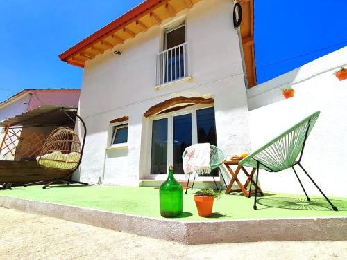 a house with two chairs and a bottle of wine at Pinheiros Tranquilos Alojamento Local Sertã in Valongo
