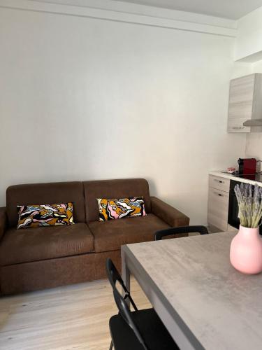 un salon avec un canapé et une table avec des chaises dans l'établissement Villa Milano Apt. n. 5, à Milan