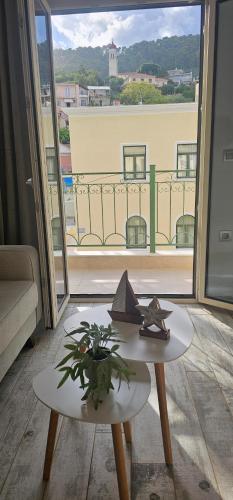 a living room with a table and a large window at Ionion Apartment in Zakynthos Town
