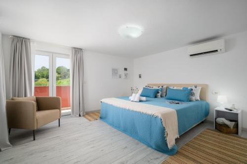 a bedroom with a blue bed and a chair at Villa Mamma Mia in Oprtalj