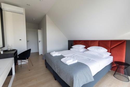 a bedroom with a large bed with a red headboard at Anaberg in Nowa Ruda