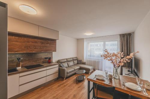 a kitchen and living room with a couch and a table at Luxusní Apartmán U Petrofa s vlastním parkovacím místem in Hradec Králové