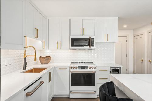 a kitchen with white cabinets and a stove and a sink at New Listing Renovated 2 BR w AC in Aspen