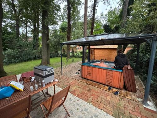 a person in a hot tub in a backyard at Irány Horány Vendégház in Szigetmonostor