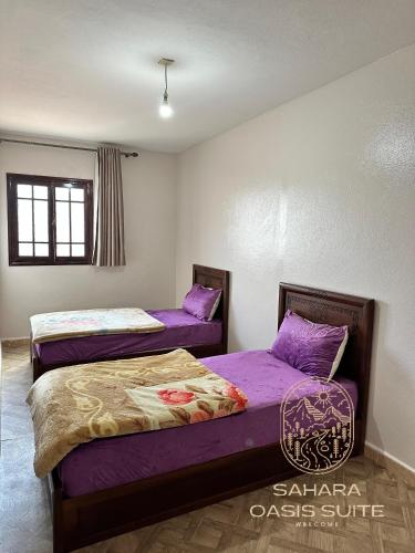 two beds in a room with purple sheets at Appartements Meublés servitio 1 in Laayoune