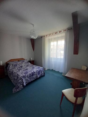 une chambre avec un lit, une table et une fenêtre dans l'établissement L Escapade Parodienne, à Paray-le-Monial