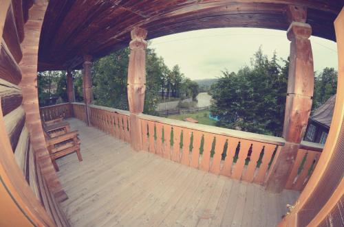 a large wooden balcony with a view of a yard at Едельвейс-Будапешт in Yasinya
