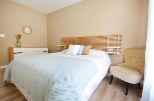 a bedroom with a large white bed and a chair at La Casa De Roma in Cambados