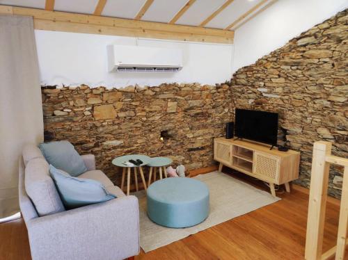 a living room with a couch and a tv at Pinheiros Tranquilos Alojamento Local Sertã in Valongo