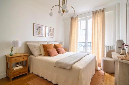 une chambre avec un lit avec des oreillers et une fenêtre dans l'établissement Deco St Antoine, à Paris