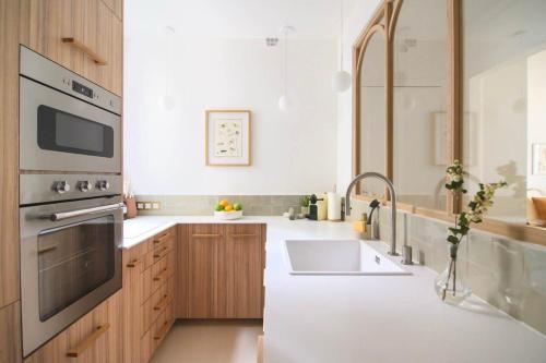 une cuisine avec un évier et une cuisinière four supérieur dans l'établissement Deco St Antoine, à Paris