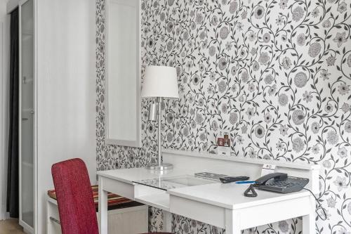 a white desk with a lamp and a red chair at Best Western Plus Edward Hotel in Lidköping