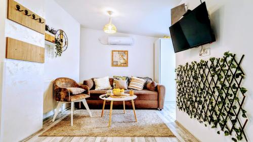 een woonkamer met een bank en een tafel bij Blue Lagoon 150m-2 minuta hoda od centra, mogucnost za parking-apartmani-nsmilos in Novi Sad