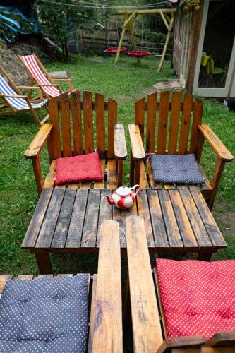 a wooden picnic table and chairs with red and blue cushions at Zimska idila in Crni Vrh
