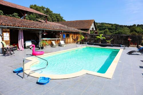- une piscine avec un flamingo rose à côté d'une maison dans l'établissement La Maison du Saula, à Lafrançaise