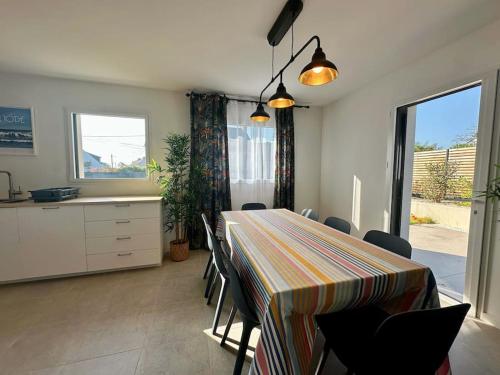 une salle à manger avec une table et des chaises dans l'établissement Maison neuve tout confort sur Arradon, à Arradon
