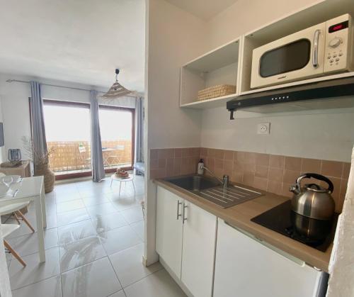 a kitchen with a sink and a microwave at Studio calme -304- in Canet-en-Roussillon