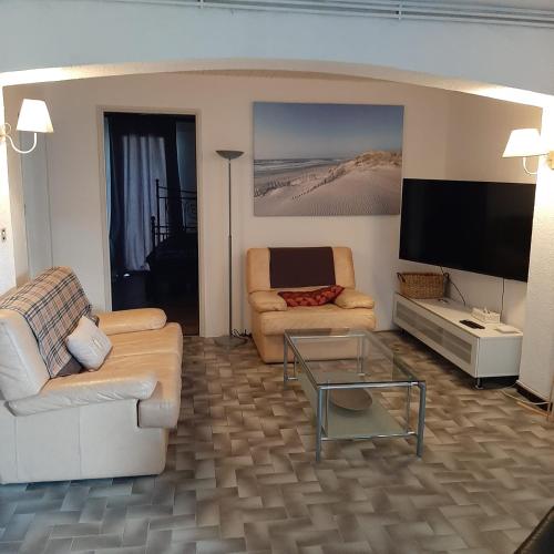 un salon avec deux canapés et une télévision à écran plat dans l'établissement Maleska, à Poussan