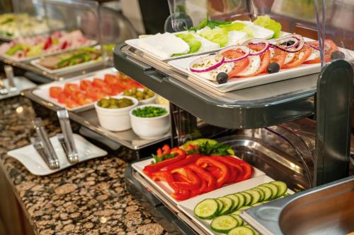a buffet line with different types of food on trays at Hotel Dworski Galaktyczny Park in Szczecin