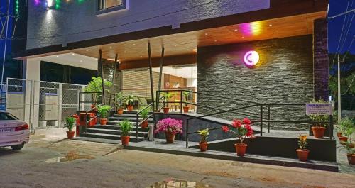 a building with potted plants in front of it at Click Hotel Vista-Kempegowda Airport in Bengaluru