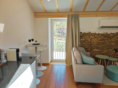 a living room with a couch and a stone wall at Pinheiros Tranquilos Alojamento Local Sertã in Valongo
