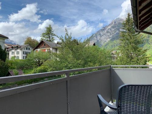 a balcony with a chair and a view of a mountain at Revier schlicht und bahnsinnig in Mitlödi
