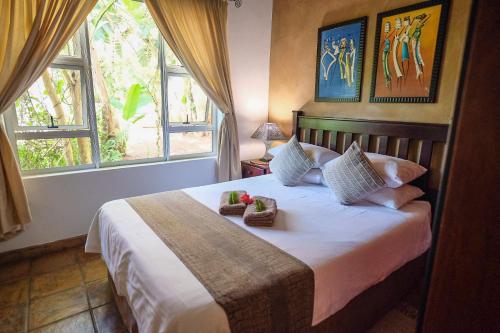 a bedroom with a bed with two towels on it at Ingwenya Lodge in St Lucia