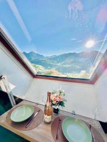 a table with two green plates and a bottle of wine at Atypical Studio - Allos in Allos