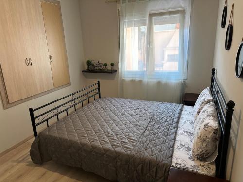 un dormitorio con una cama y una ventana en OlympiaHouse, en Drama