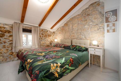 a bedroom with a bed and a stone wall at Cozy Studio-Apartment inmitten der Altstadt von Porec und nur 50 Meter zur Adria in Poreč