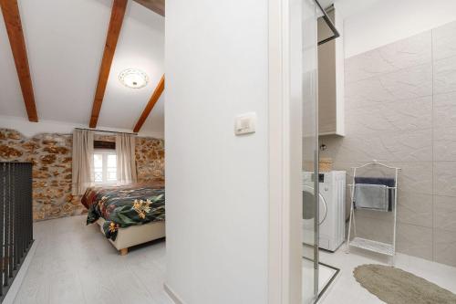 a bedroom with a bed and a refrigerator in a room at Cozy Studio-Apartment inmitten der Altstadt von Porec und nur 50 Meter zur Adria in Poreč