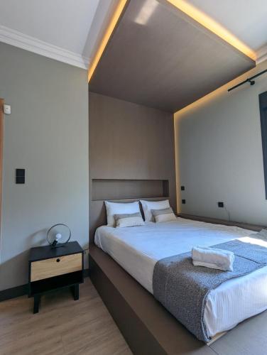 a bedroom with a large bed and a table at Be My Guest Athens in Athens