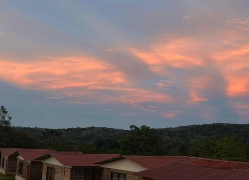 a cloudy sky with buildings and trees in the background at Cabañas venado in Venado