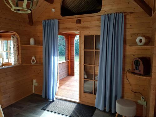 a room with blue curtains in a log cabin at Familienfreundliches Ferienhaus am Grinderwald nah Steinhuder Meer in Neustadt am Rübenberge