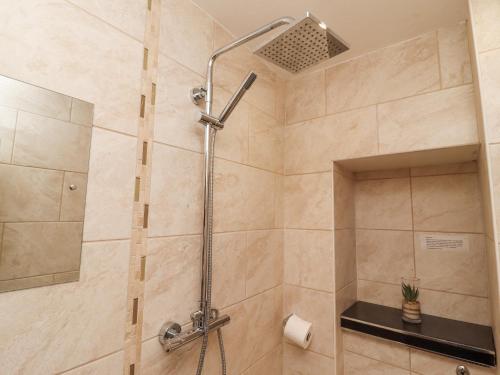 a shower with a shower head in a bathroom at Heron in St Ives