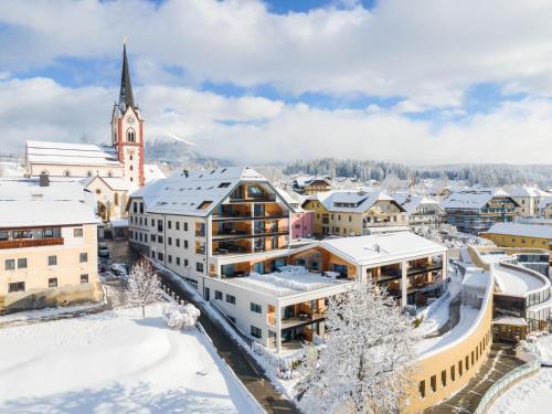 a city in the snow with a church at AlpenParks Hotel & Apartment Carpe Solem Mariapfarr in Mariapfarr