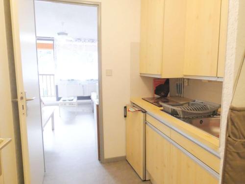 une cuisine avec un chat assis au-dessus d'un comptoir dans l'établissement Appartement T2 avec Balcon pour 4 pers - Saint-Lary-Soulan - Sud-Est avec Parking et Casier à Ski - FR-1-457-332, à Saint-Lary-Soulan