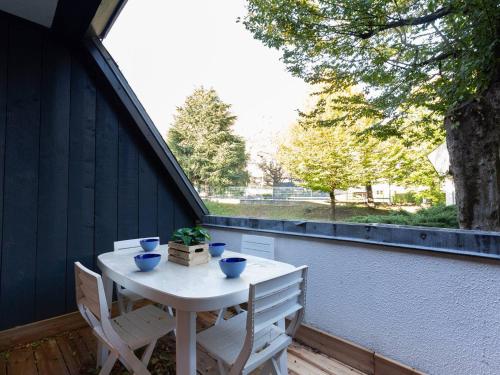 - une table et deux chaises sur une terrasse couverte avec une fenêtre dans l'établissement Appartement rénové avec sauna, piscine, et parking à Saint Lary Village - 4 pers - FR-1-296-371, à Saint-Lary-Soulan