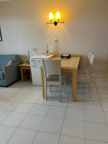 une salle à manger avec une table et des chaises et une cuisine dans l'établissement Studio vue sur mer, à Fréjus