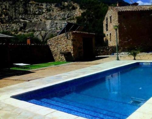 a swimming pool in front of a building with a mountain at Miramar in Montblanc